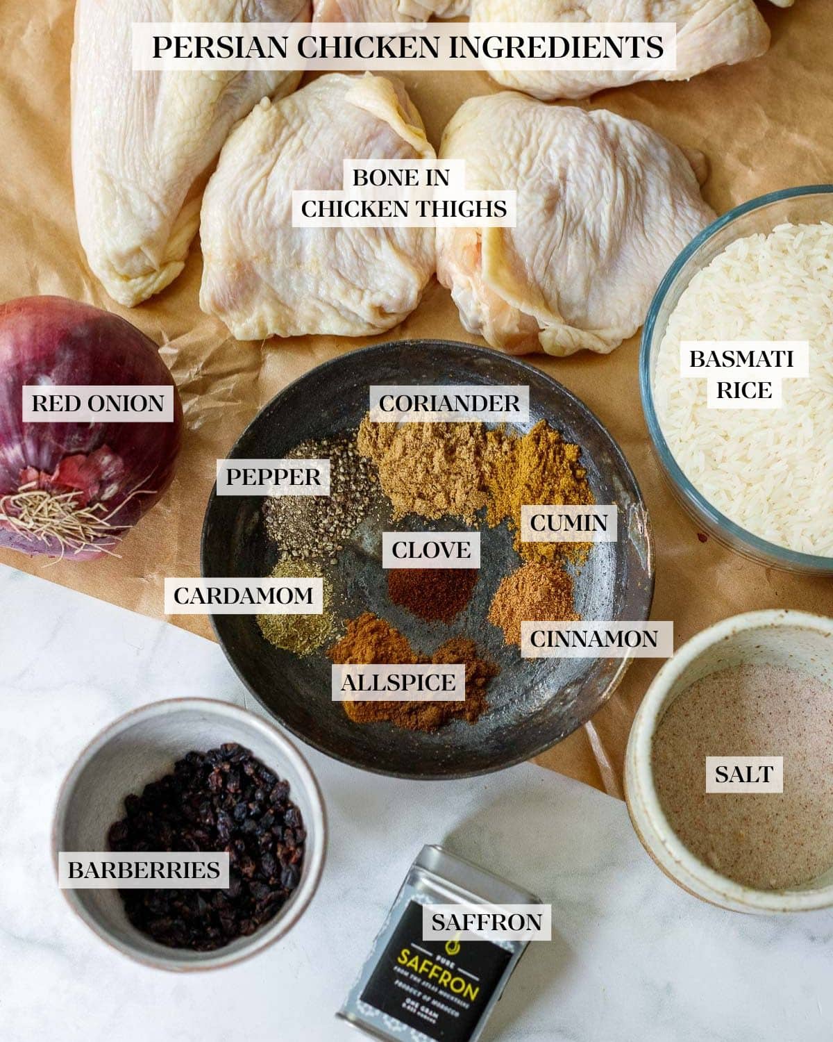 ingredients for persian chicken on parchment paper - chicken, rice, spices, onion, salt, barberries