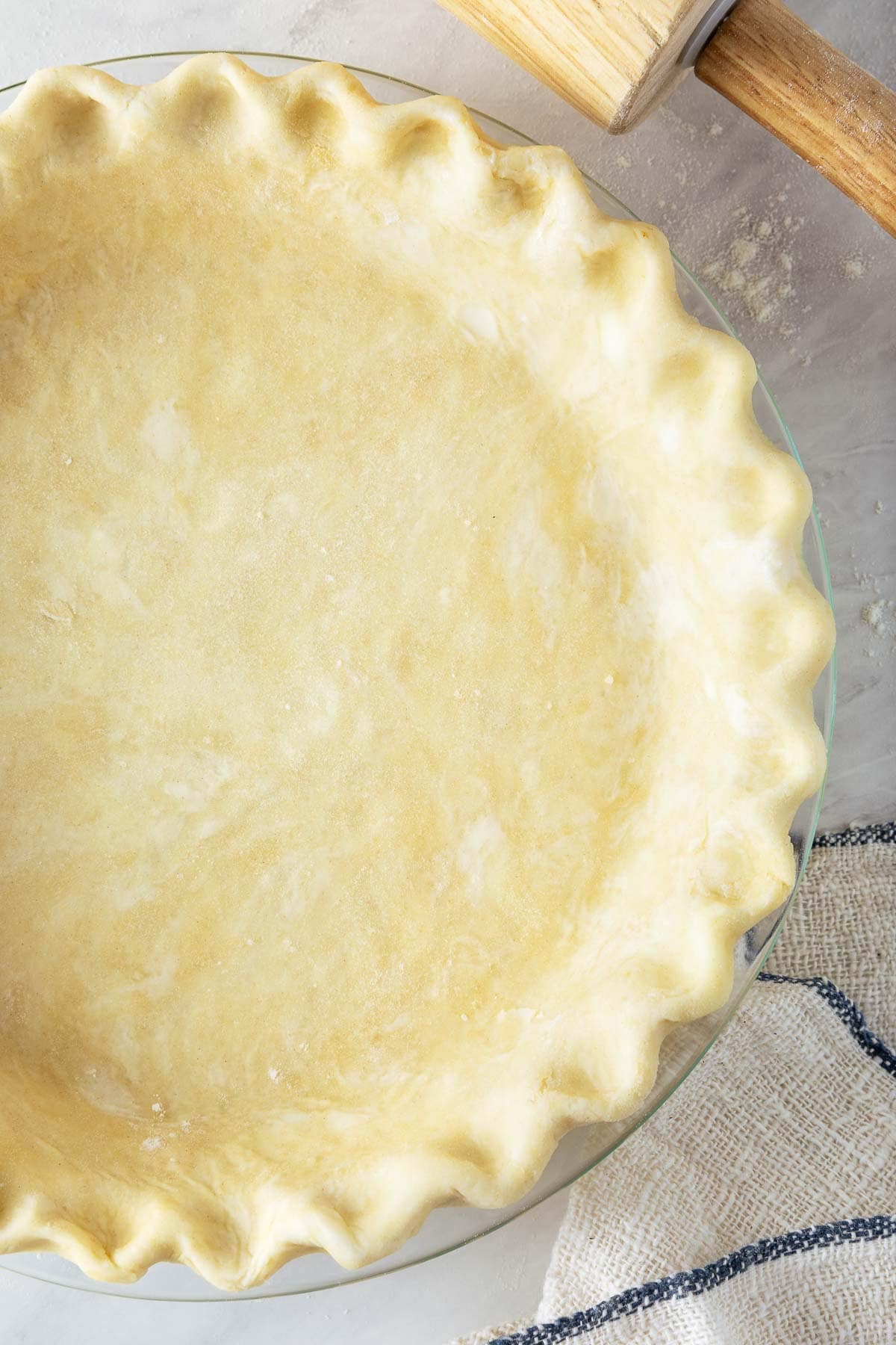 pie crust in glass pie pan with crimped edges. 