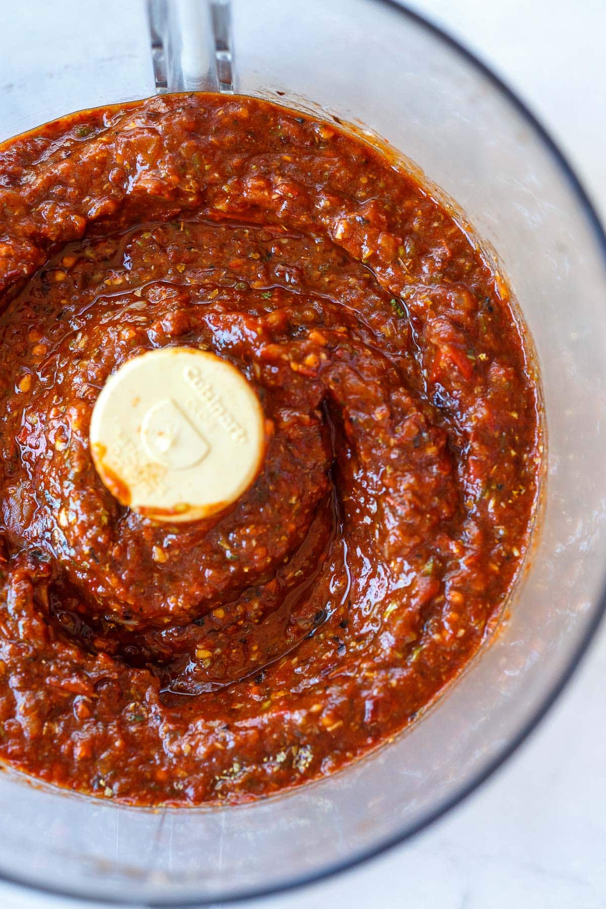 textured salsa roja blended in bowl of food processor.