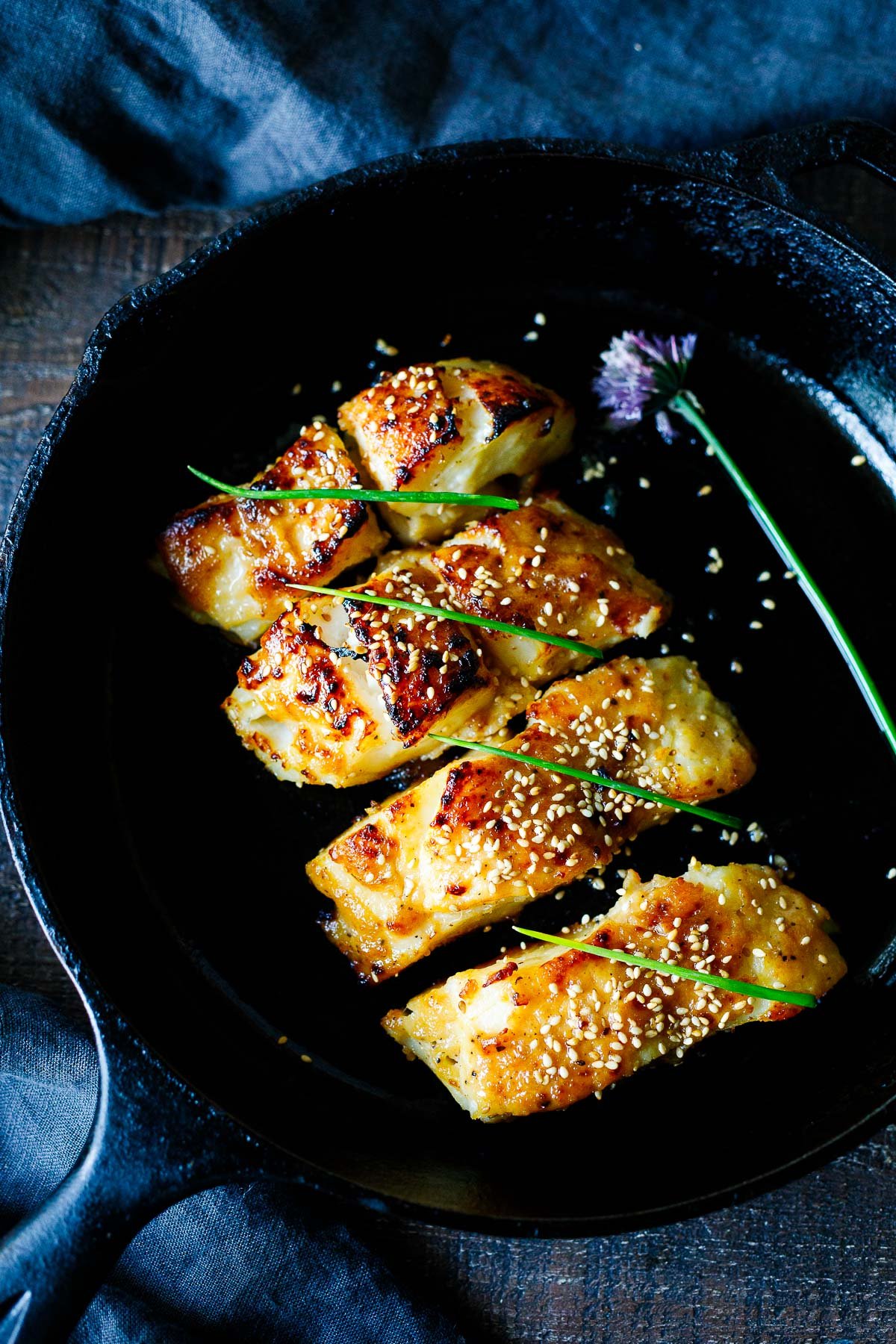 Miso black cod, with sesame seeds and chives in a skillet. 