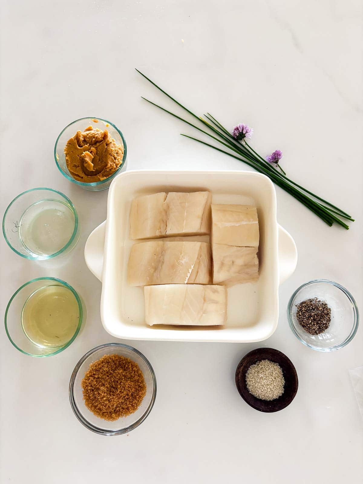 Ingredients on a white counter for miso black cod. 