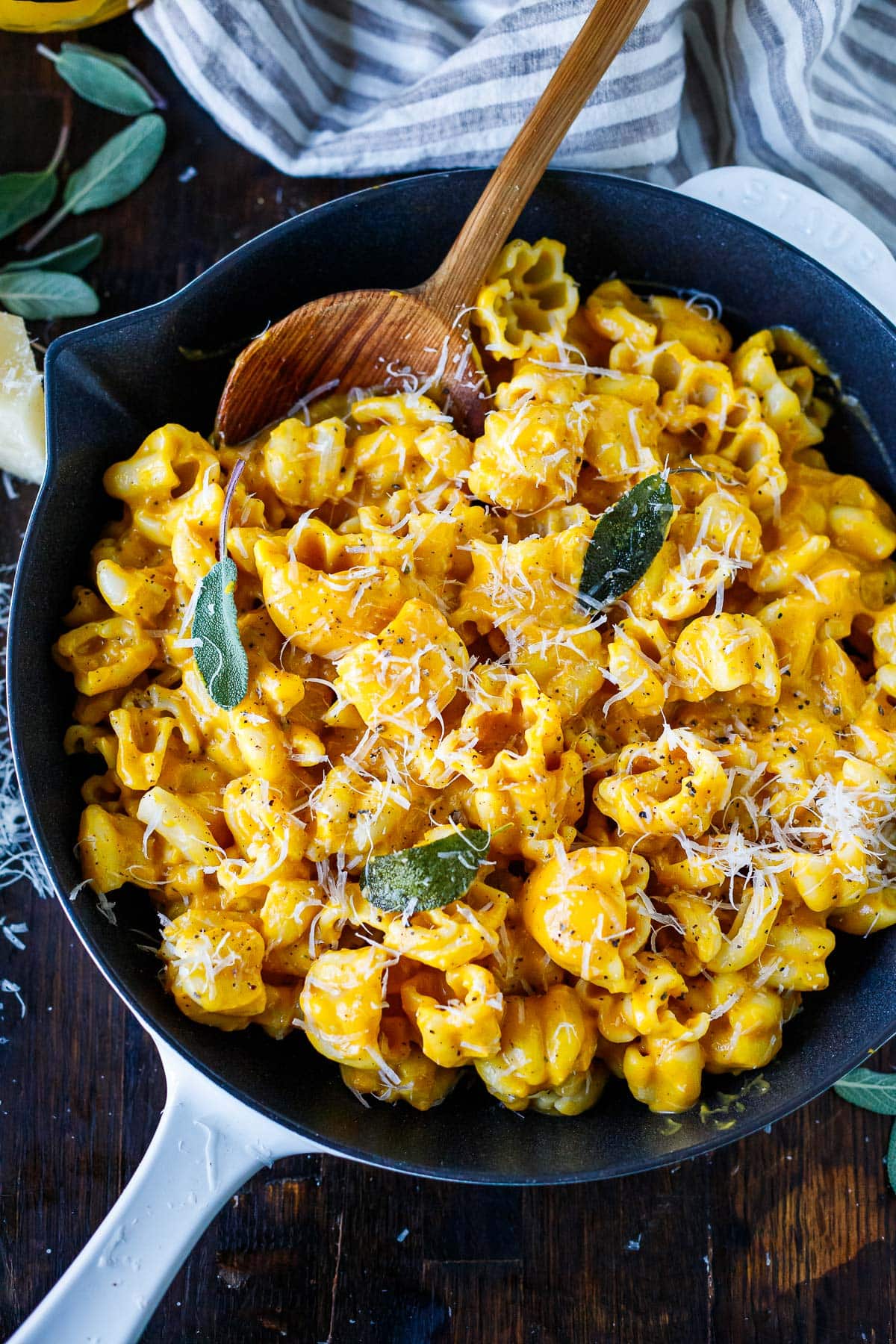 skillet with zucchette noodles tossed with butternut pasta sauce topped with shaved pecorino and sage leaves.