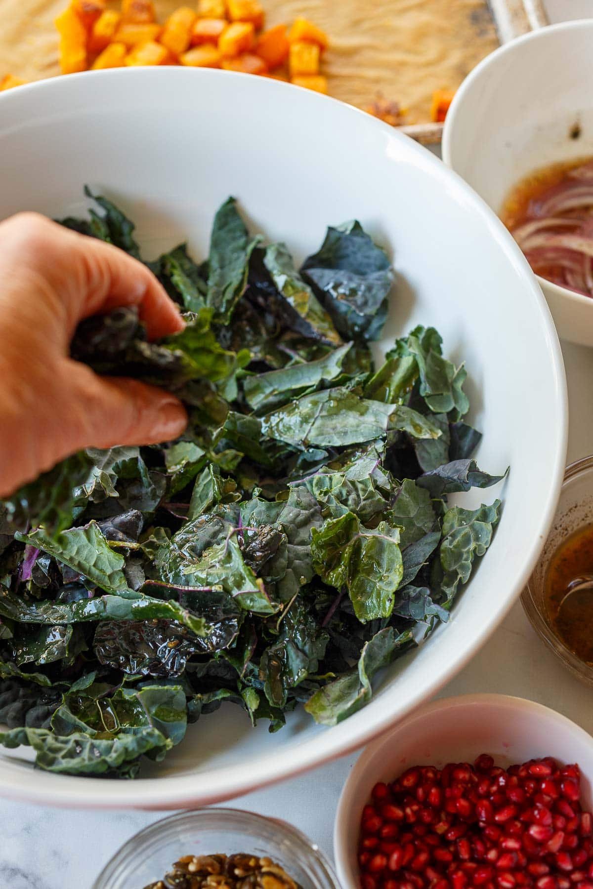 hand massaging lacinato kale with dressing.