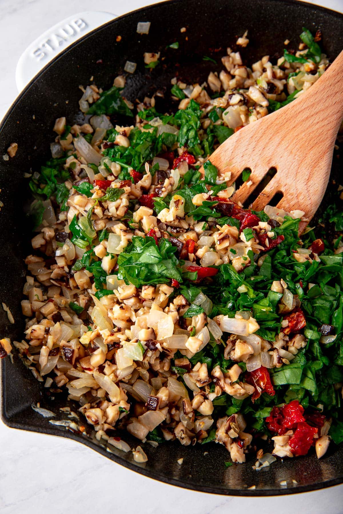 dutch oven with sautéed mushrooms, onions, sundried tomatoes, and spinach.