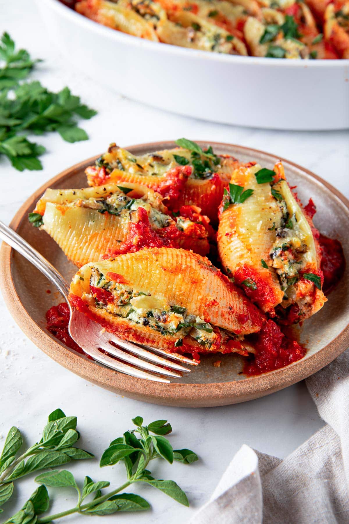 plate with four stuffed shells with spinach ricotta mixture and marinara.