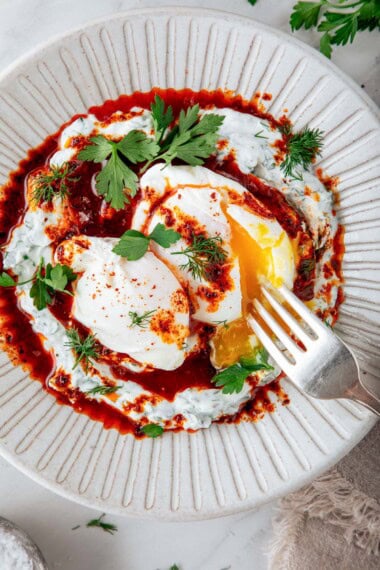 This Turkish Eggs recipe (Çılbır) features garlicky, herbed yogurt, soft-poached eggs, and a warm Aleppo butter sauce for a bold-flavored, low-carb, savory breakfast or brunch. Video.