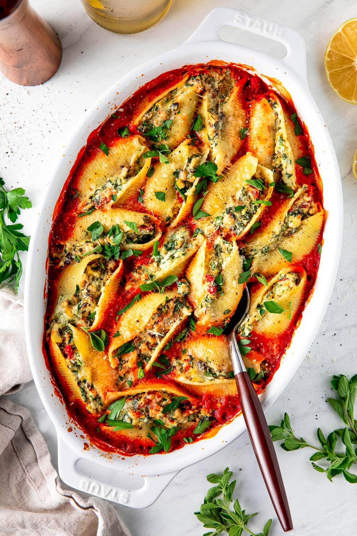 stuffed shells in a a white oval baking dish. 