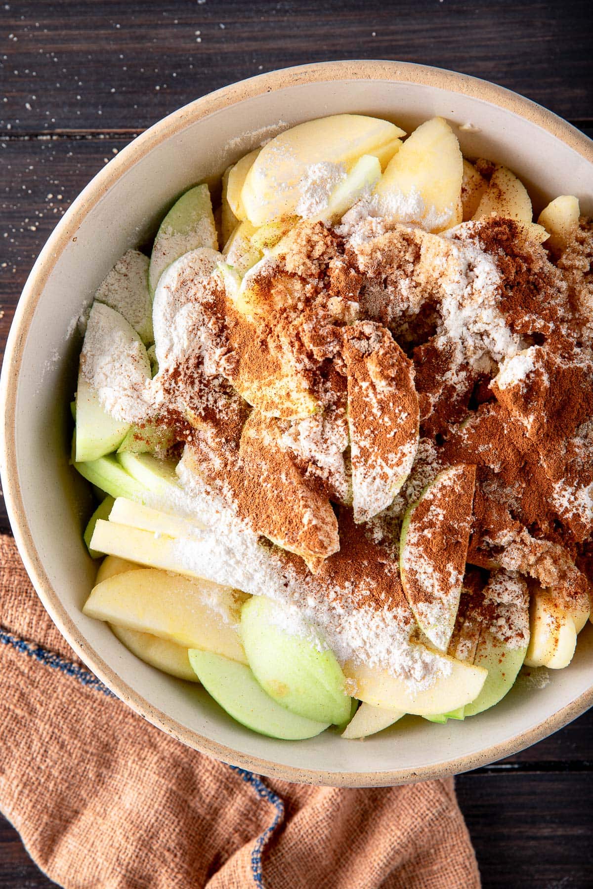 bowl of sliced apples with flour and spices.