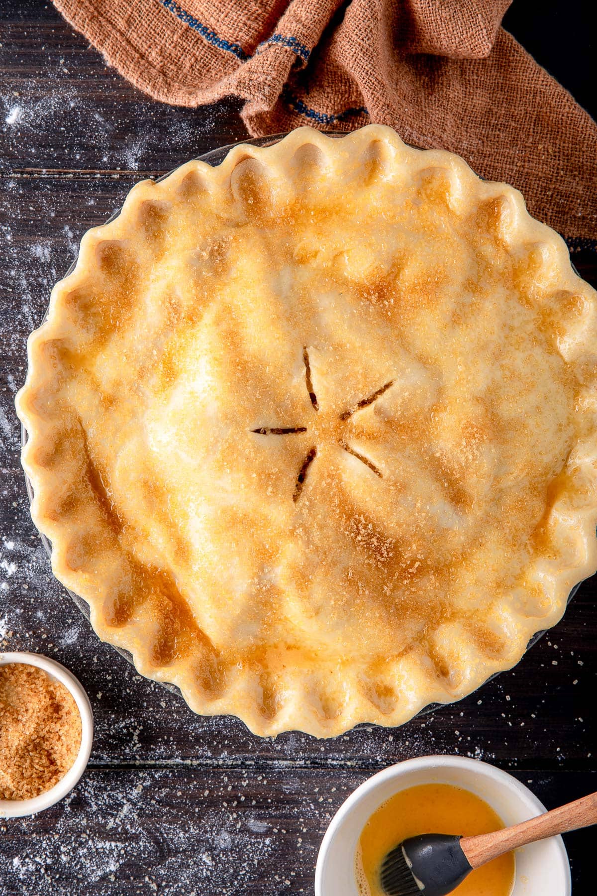apple pie before baking with crimped crust with five slits in shape of star, sprinkled with coarse sugar.