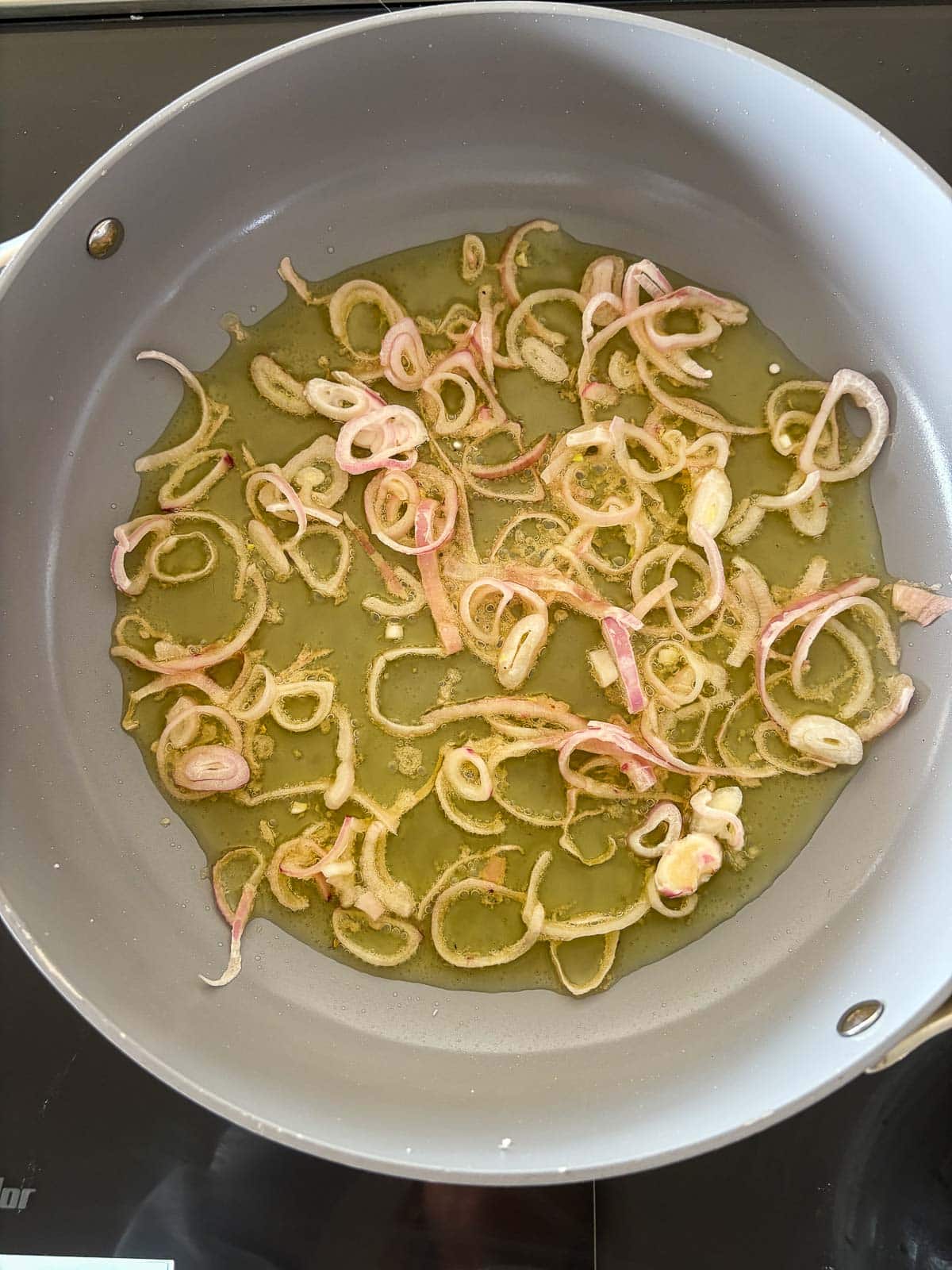 frying pan with shallots in oil. 