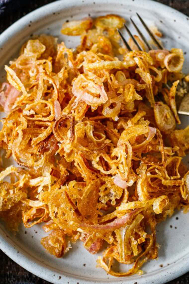 Learn our secret for crispy, light, and super-flavorful fried shallots. Easy to make, use them as a crunchy topping for sides, soups, or anything that needs a little boost of texture and punchy flavor.