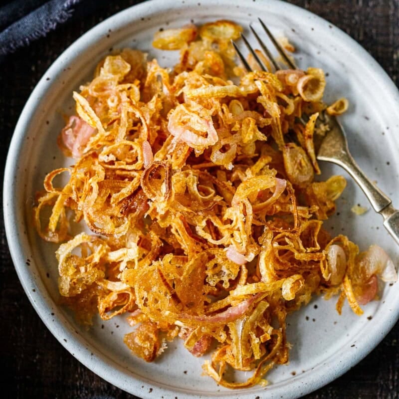 Learn our secret for crispy, light, and super-flavorful fried shallots. Easy to make, use them as a crunchy topping for sides, soups, or anything that needs a little boost of texture and punchy flavor.