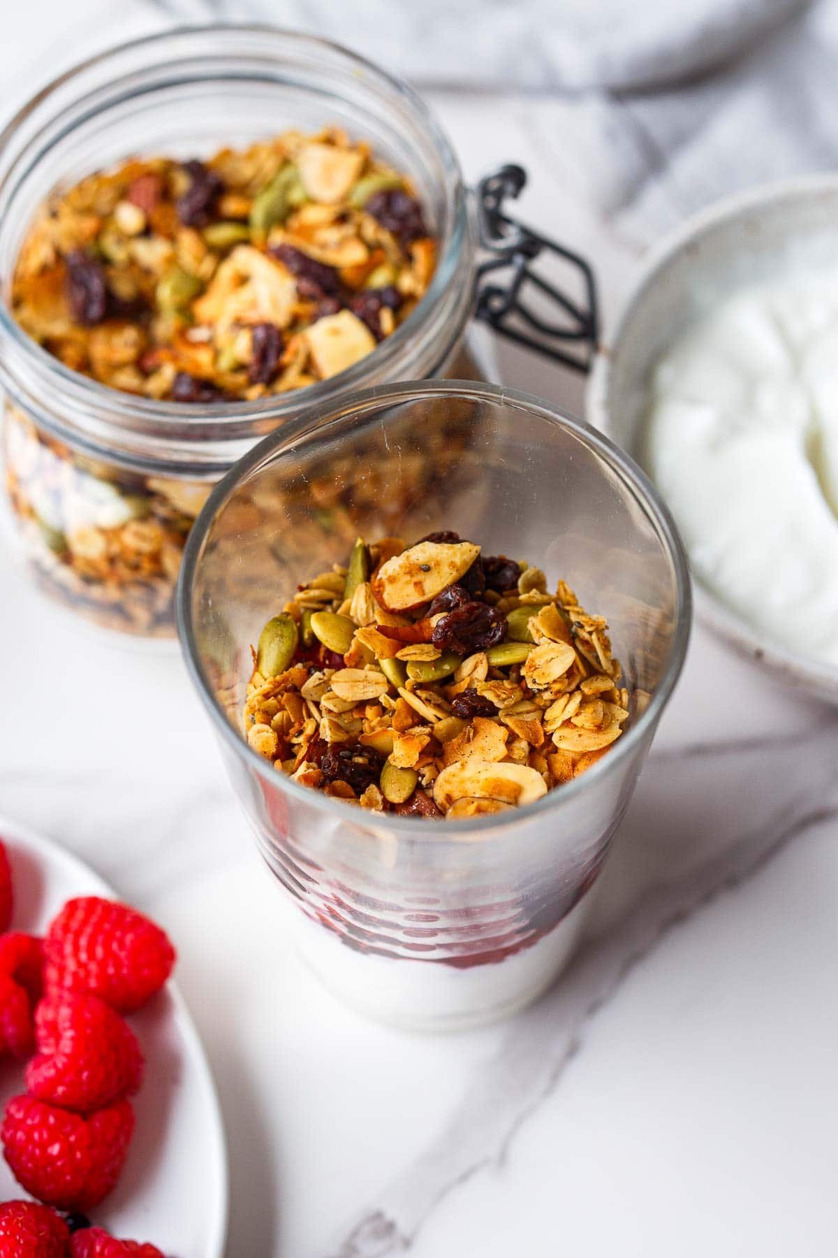 yogurt parfait with glass jar topped with granola. 
