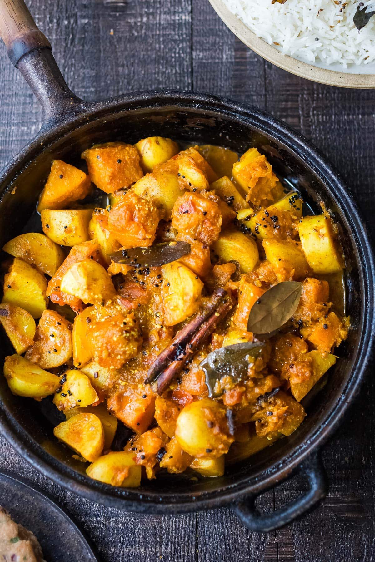 Butternut and potato curry with Indian spices in a skillet.