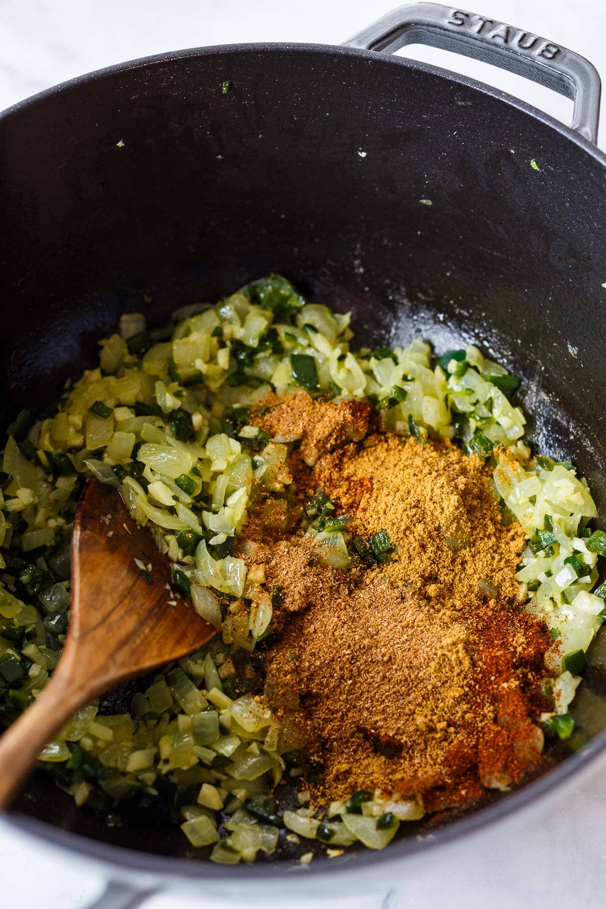 Adding the spices to the pot to toast them. 
