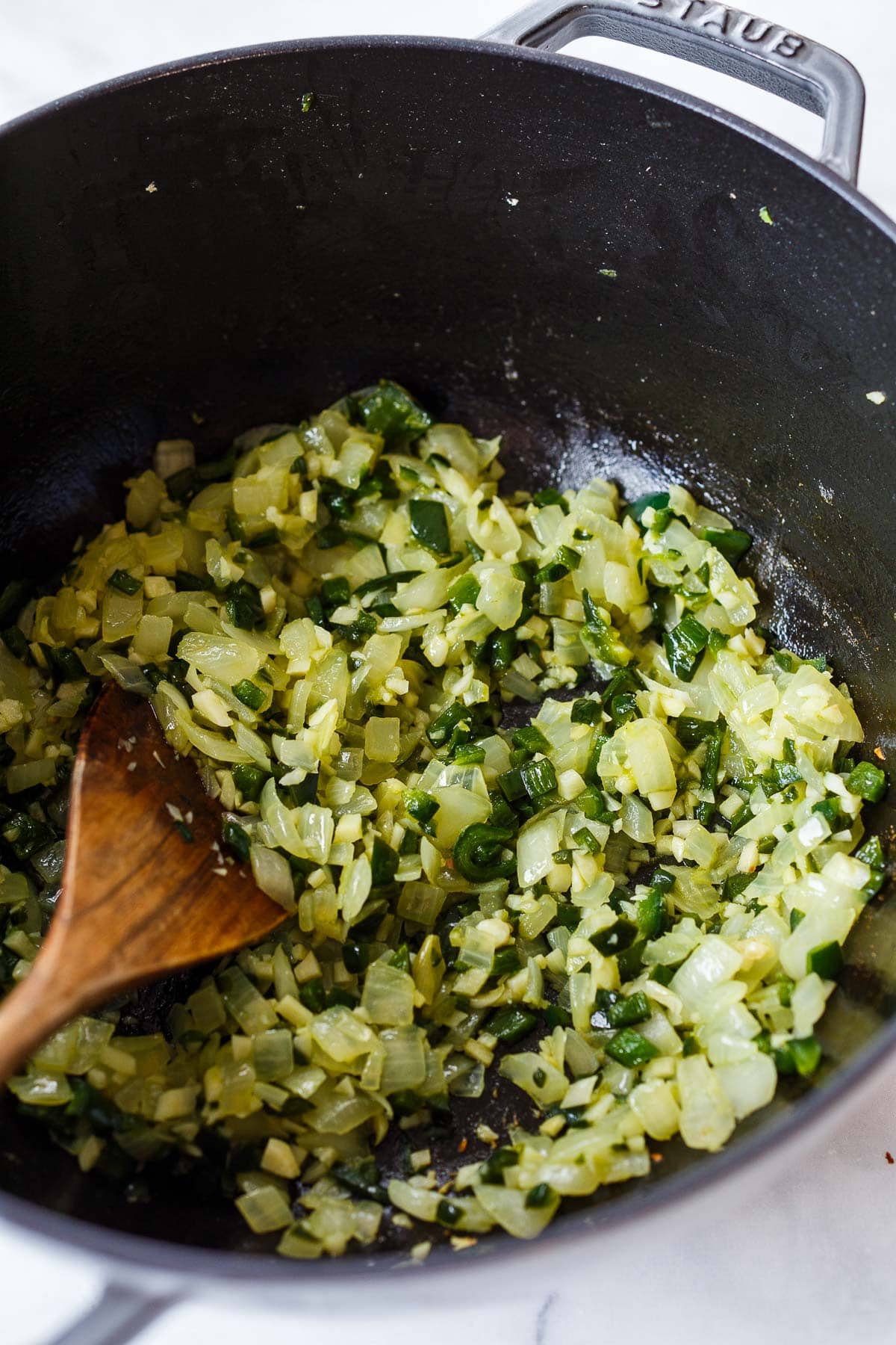 Saute onion, garlic, poblano peppers in a Dutch oven. 