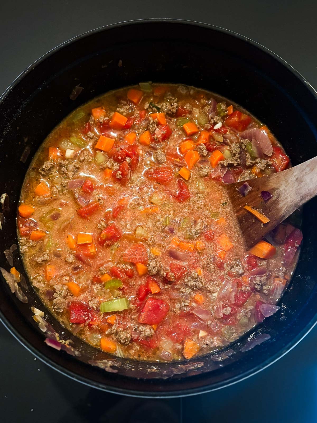 simmering bolognese sauce in large pot.