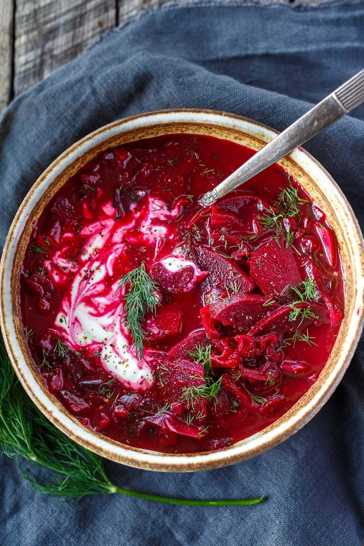 bowl of beet borscht with yogurt and fresh dill.