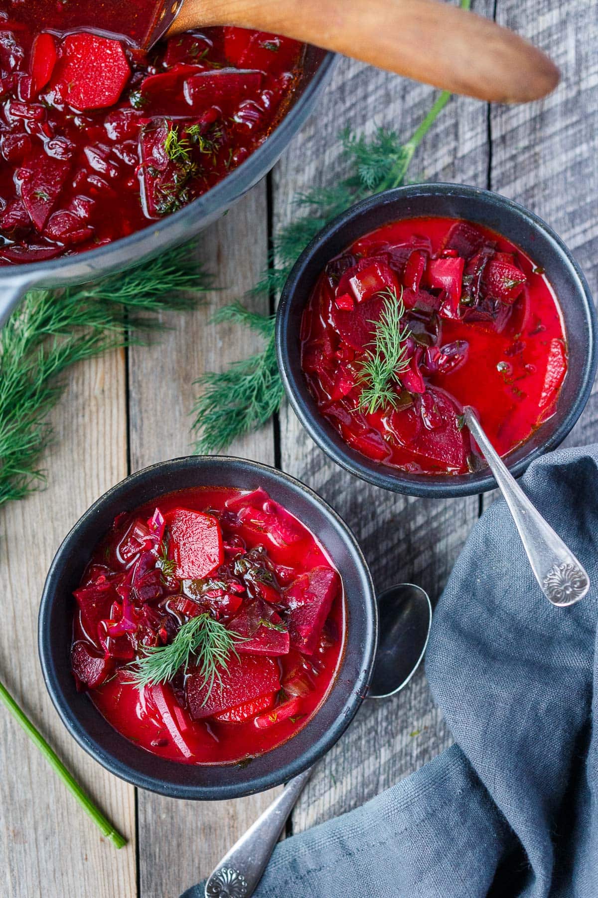 two bowls of beet borscht with fresh dill.
