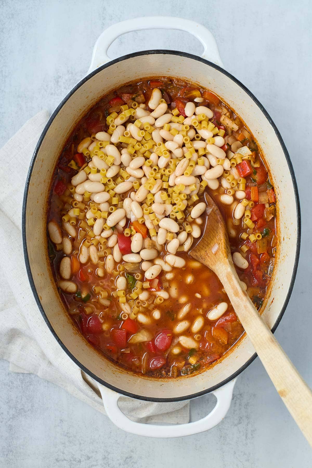 dutch oven with vegetable soup with cannellini beans and ditalini pasta added.