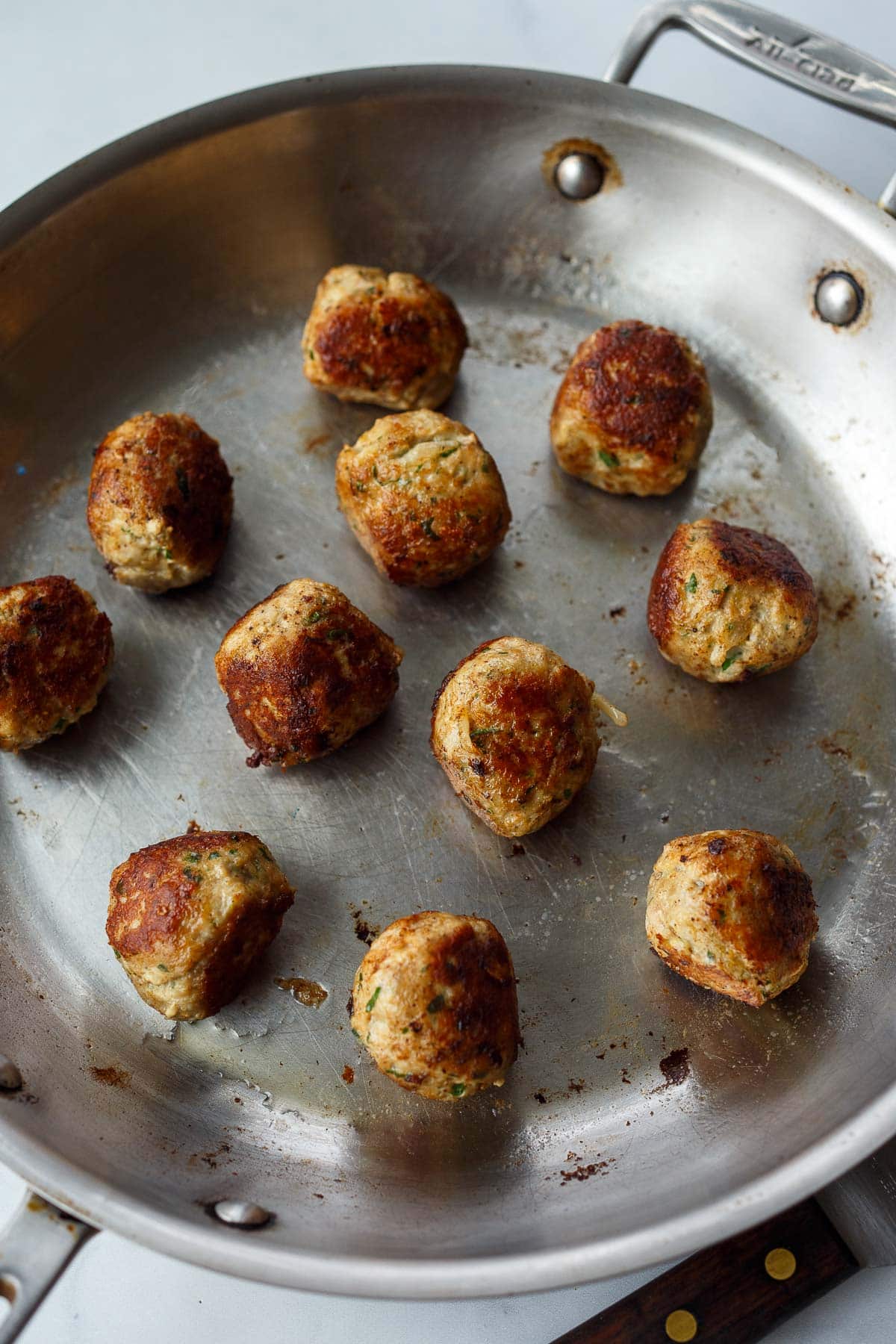 Swedish meatballs browning in skillet.
