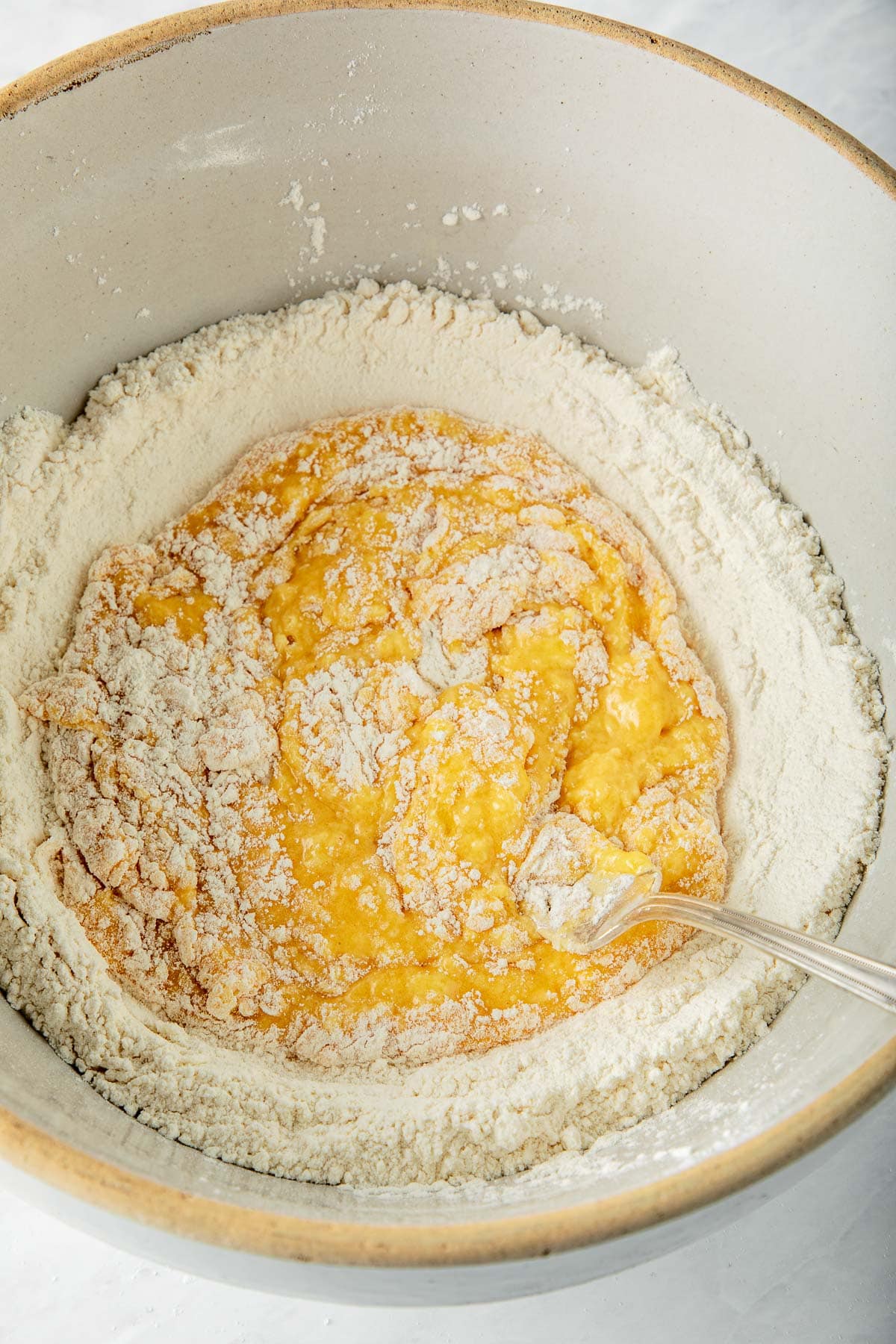 mixing bowl with fork whisking eggs with flour. 