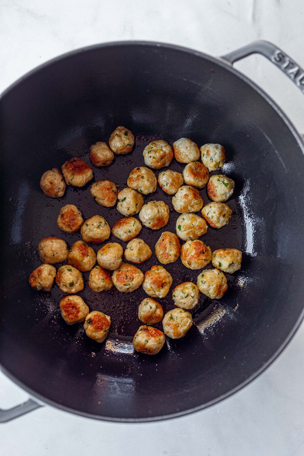 mini meatballs searing in skillet. 