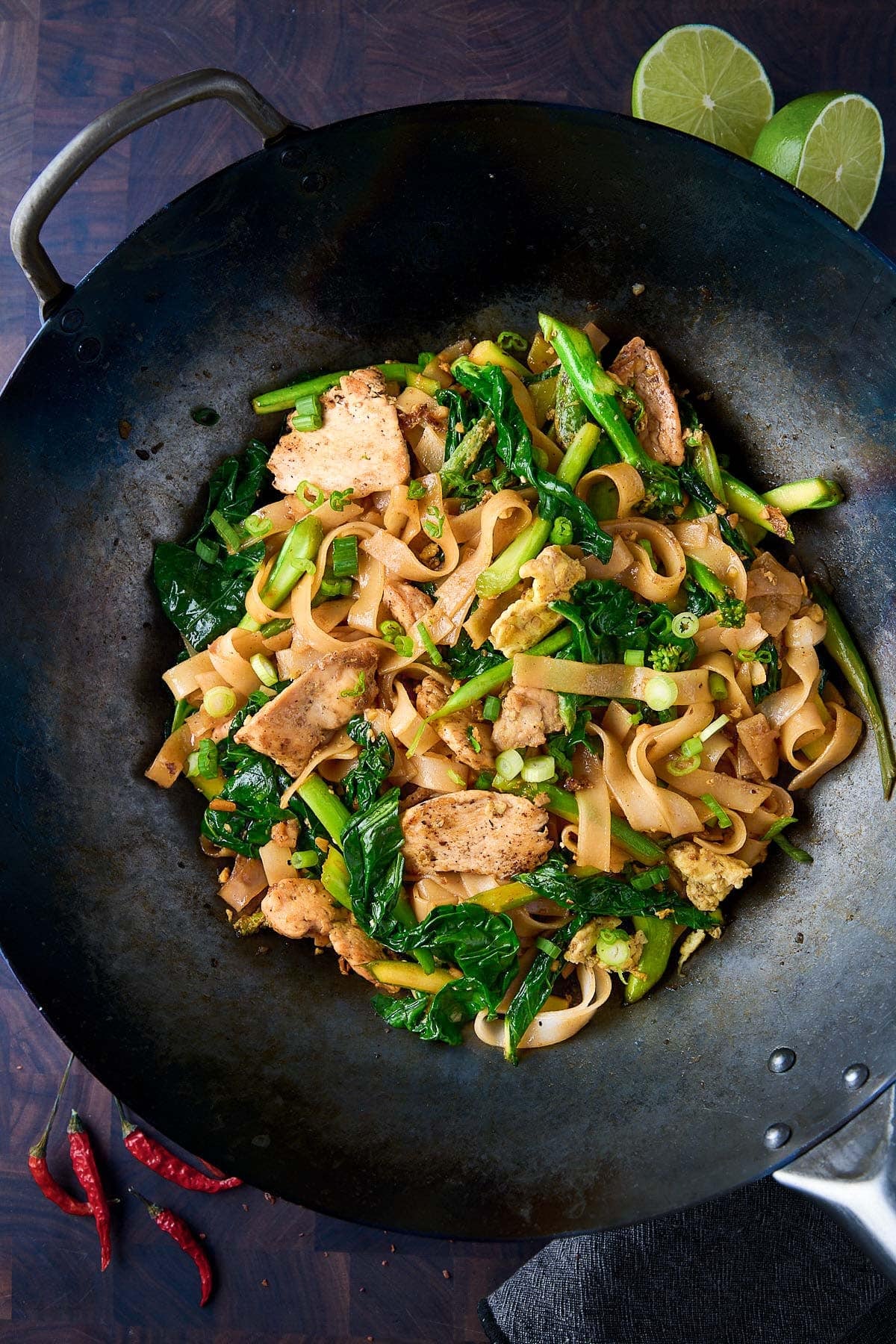 pad see ew in wok with seared chicken and Chinese broccoli. 