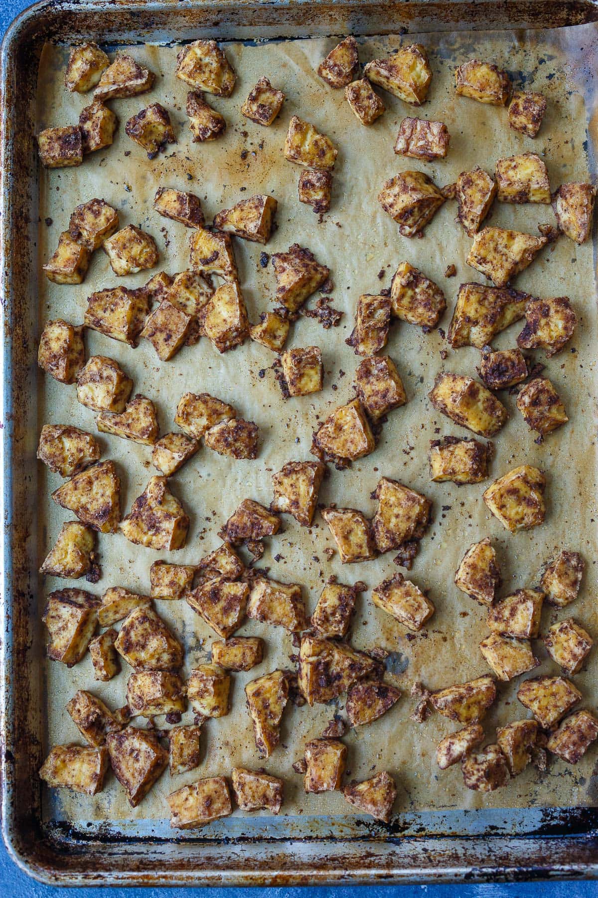 baked garam masala tofu on parchment-lined baking sheet.