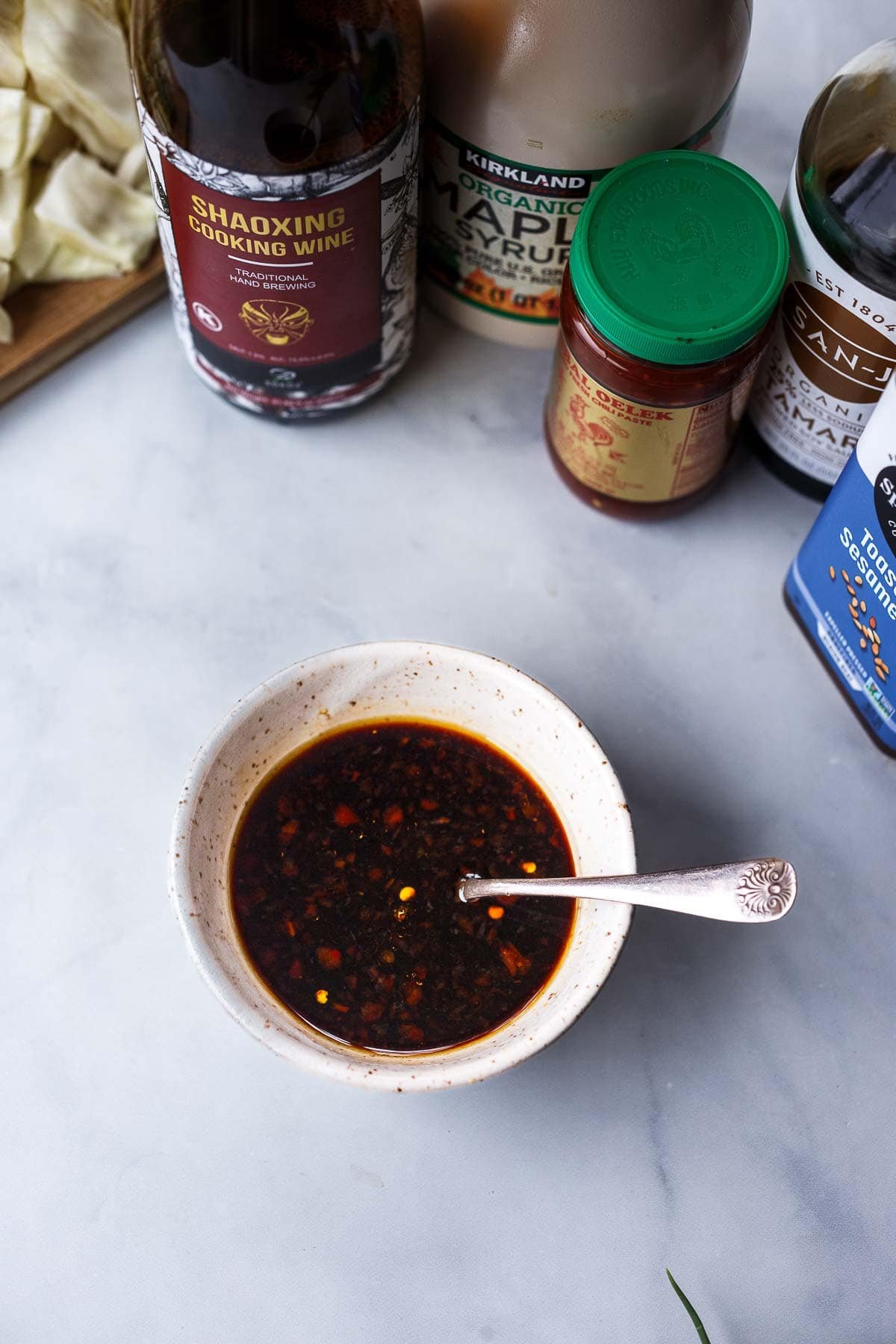 small bowl of stir fry sauce with bottled ingredients behind. 
