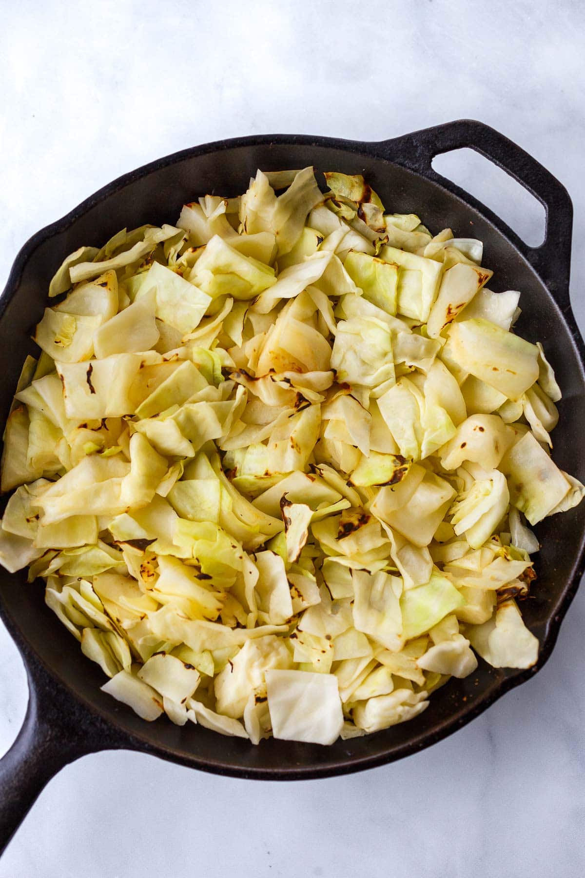 chopped green cabbage in cast iron skillet. 