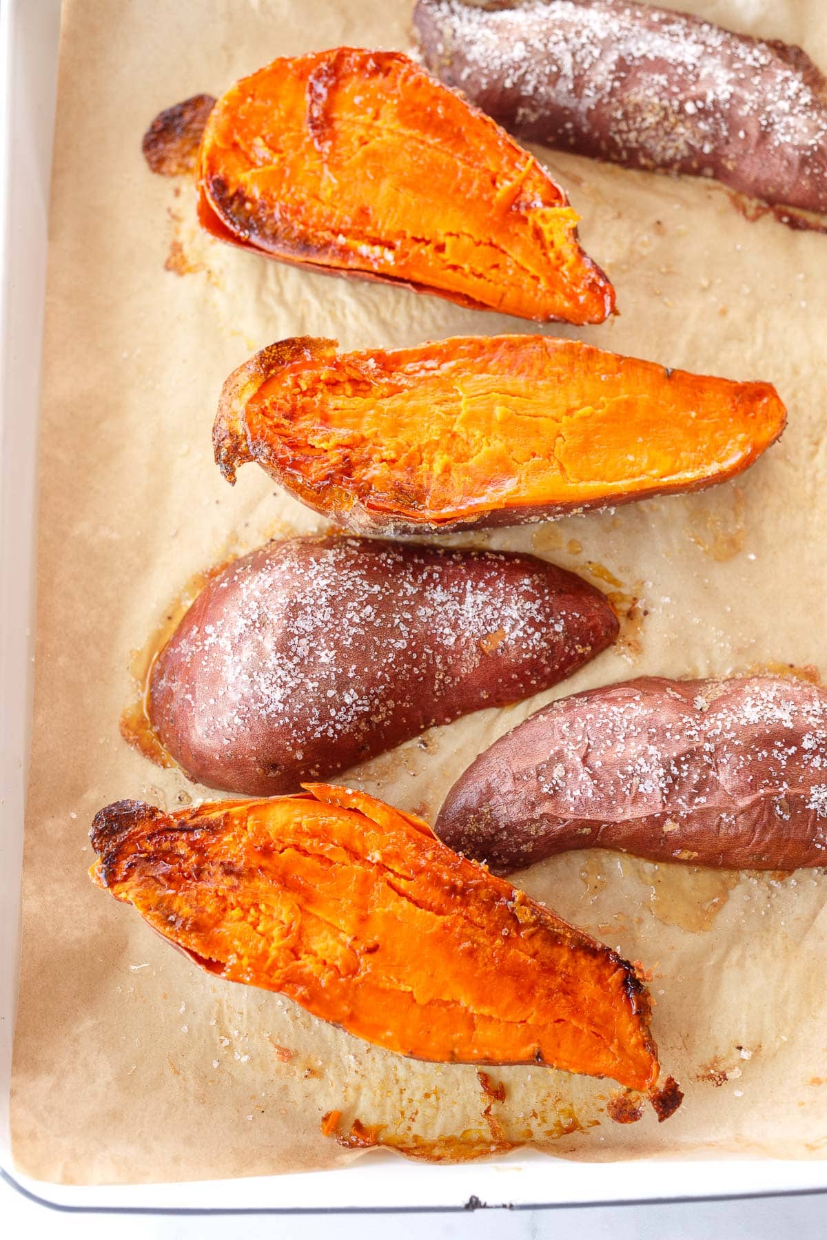 baked sweet potato halves on parchment-lined baking sheet.