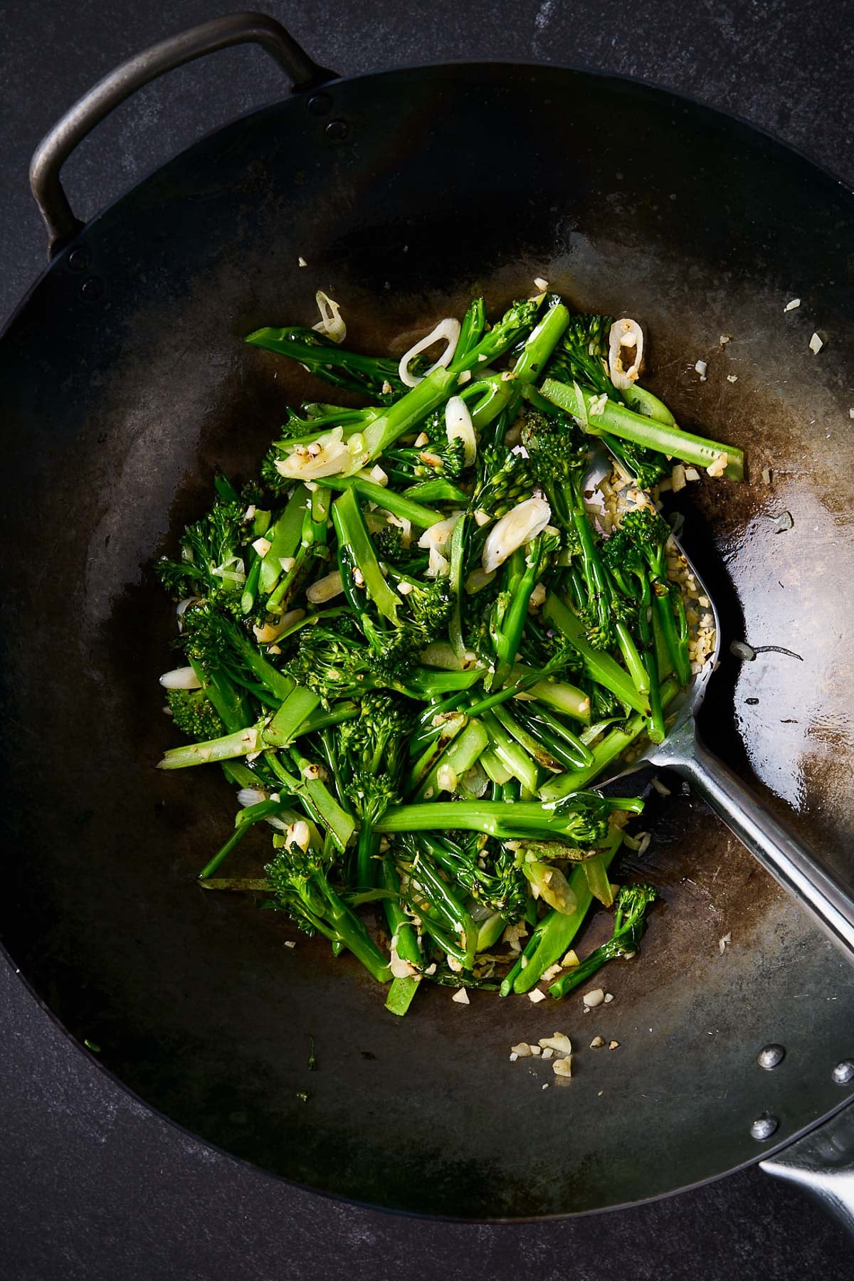 large wok with broccolini, scallions, and garlic. 
