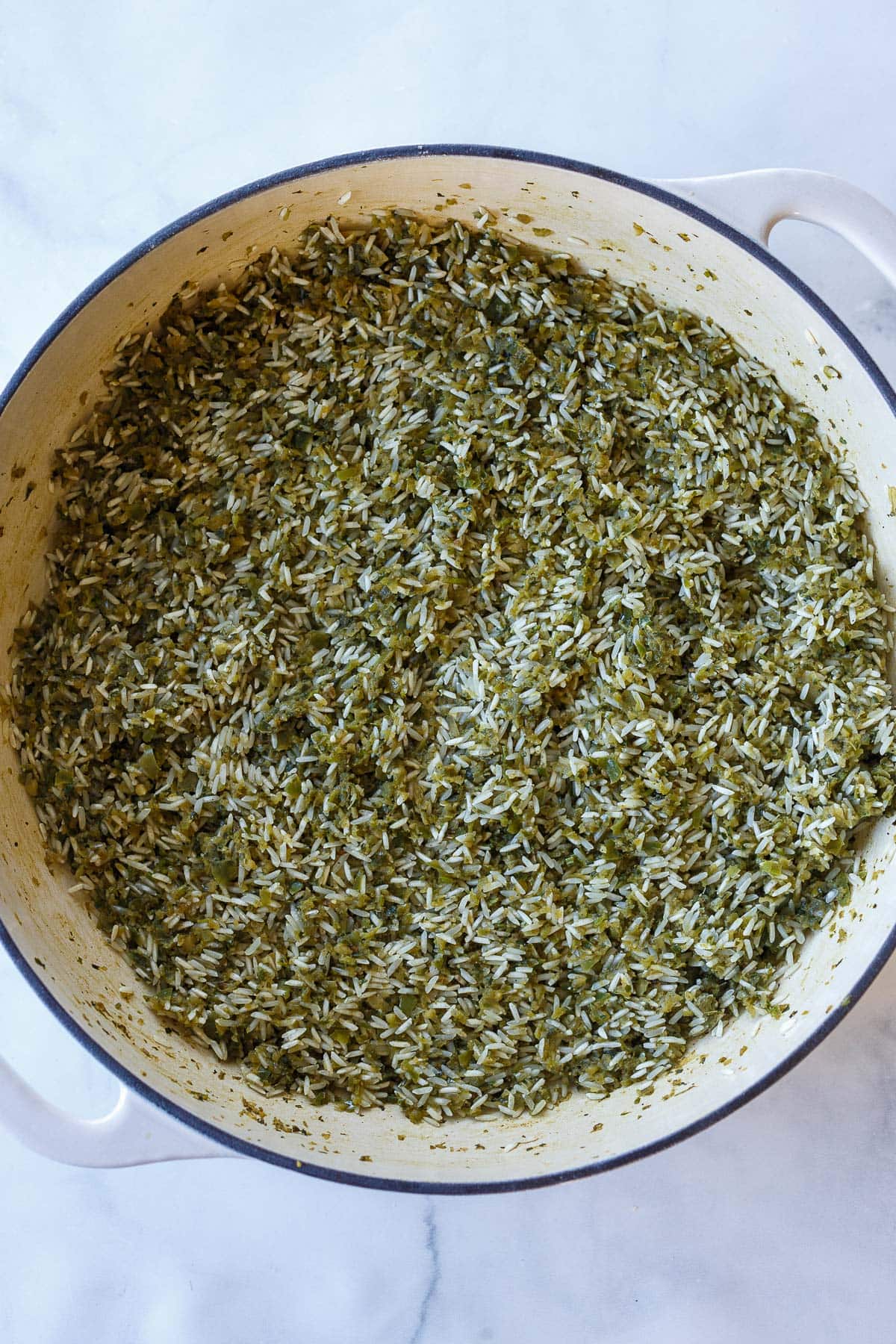 Dutch oven with long grain rice pressed into veggie herb paste. 