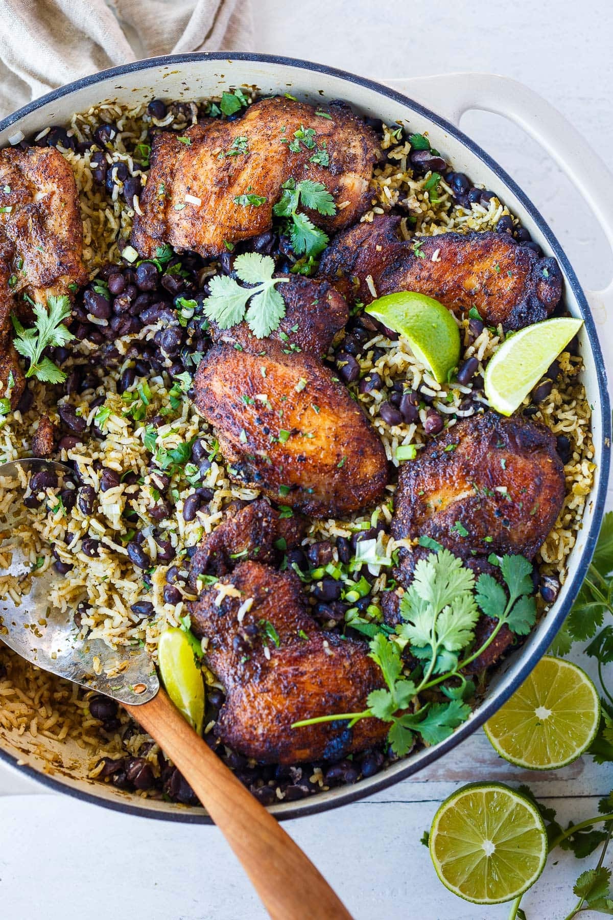 Mexican chicken skillet with rice and beans, lime wedges, and fresh cilantro. 