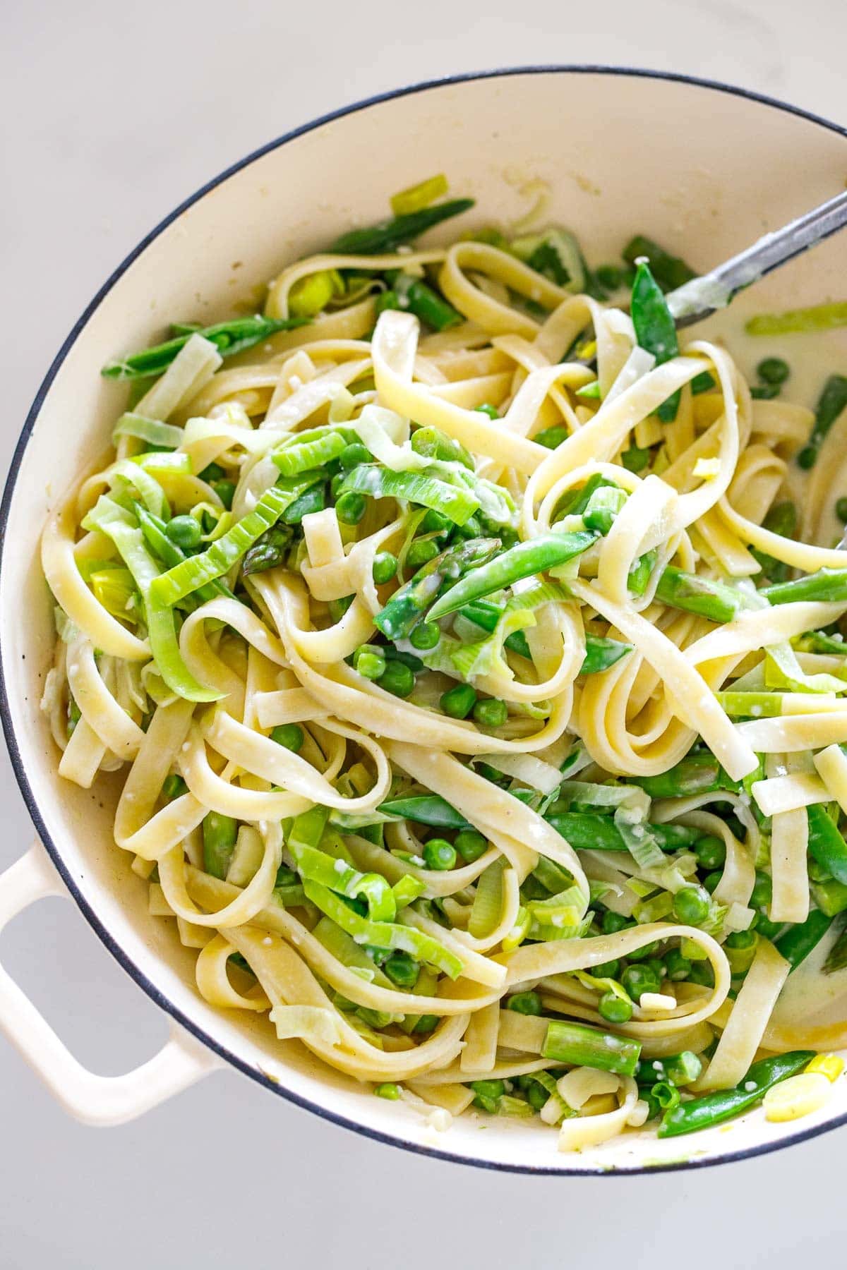 Tossing to the pasta primavera with cheese, pasta water and cream to combine well. 