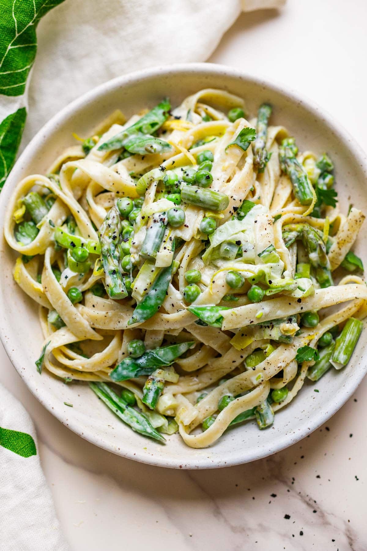 This light and creamy pasta primavera makes the perfect spring dinner! Tender pasta and spring vegetables are kissed with a light cream sauce infused with lemon and herbs.  