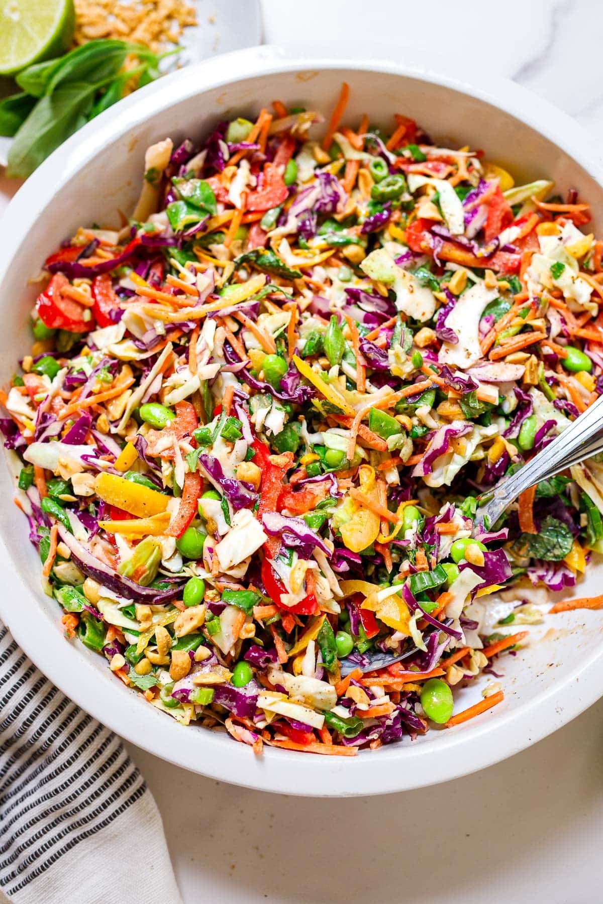 Thai salad - bowl with colorful Thai salad with veggies and herbs and peanuts, with peanut dressing. 