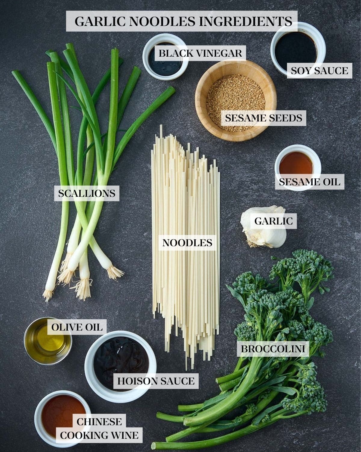 ingredients for garlic noodles - scallions, sesame seeds, noodles, garlic, broccolini, and various sauces in small bowls. 