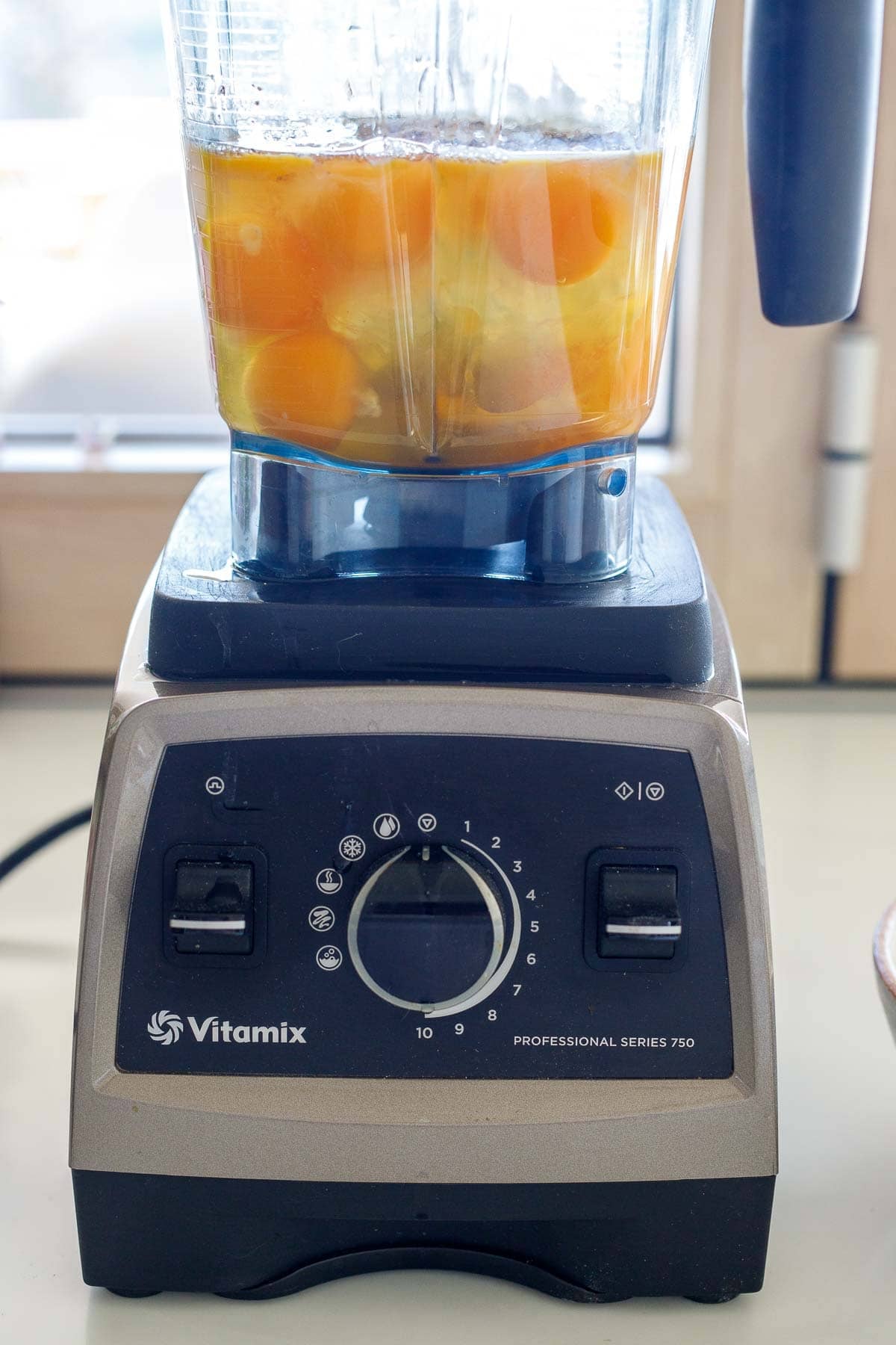 vitamix blender with eggs and other ingredients needed for breakfast casserole. 