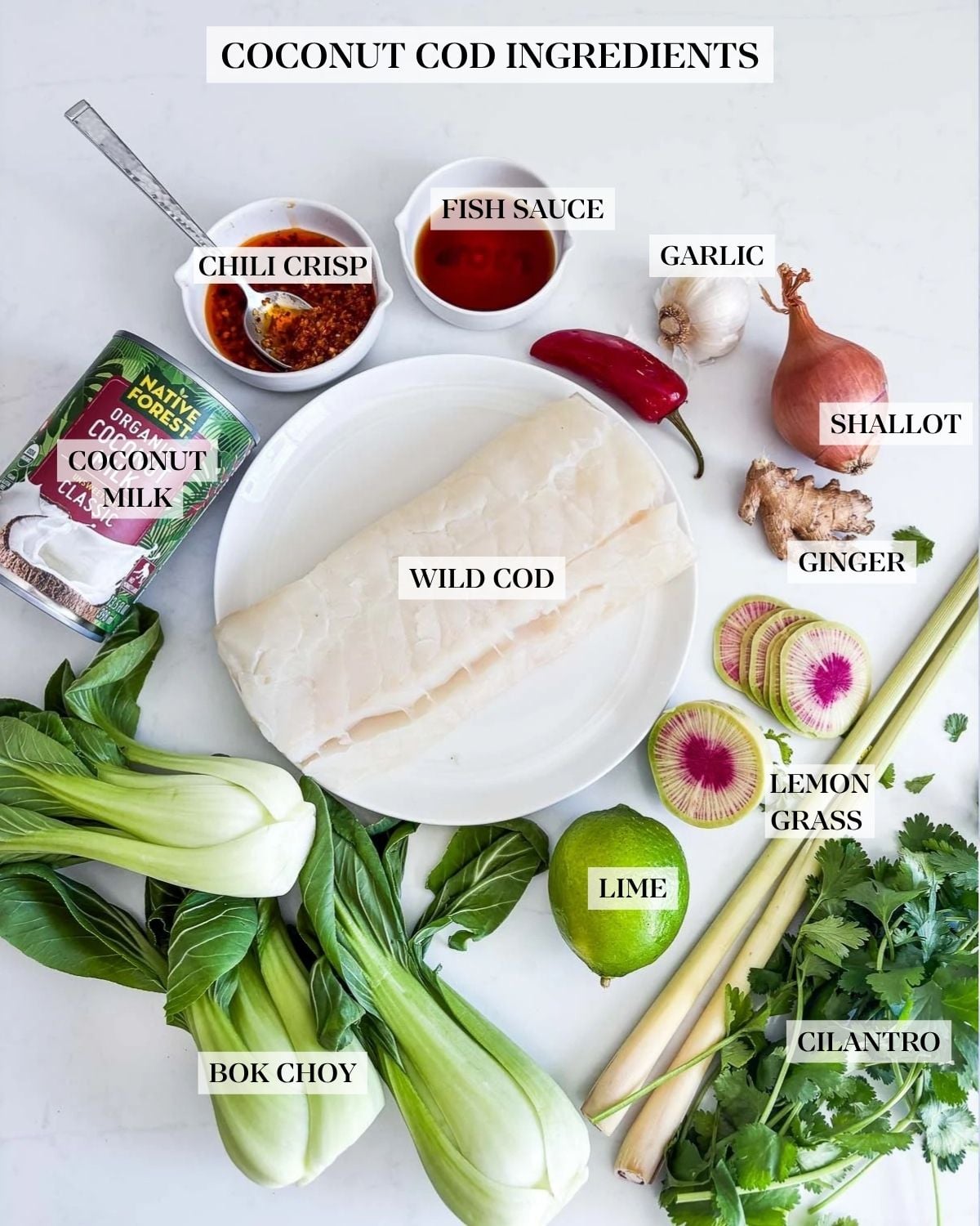 coconut cod recipe ingredients - uncooked cod on plate, coconut milk, chili crisp, soy sauce, red chili, garlic, shallot, ginger, sliced watermelon radish, lime, lemongrass, fresh cilantro, baby bok choy.
