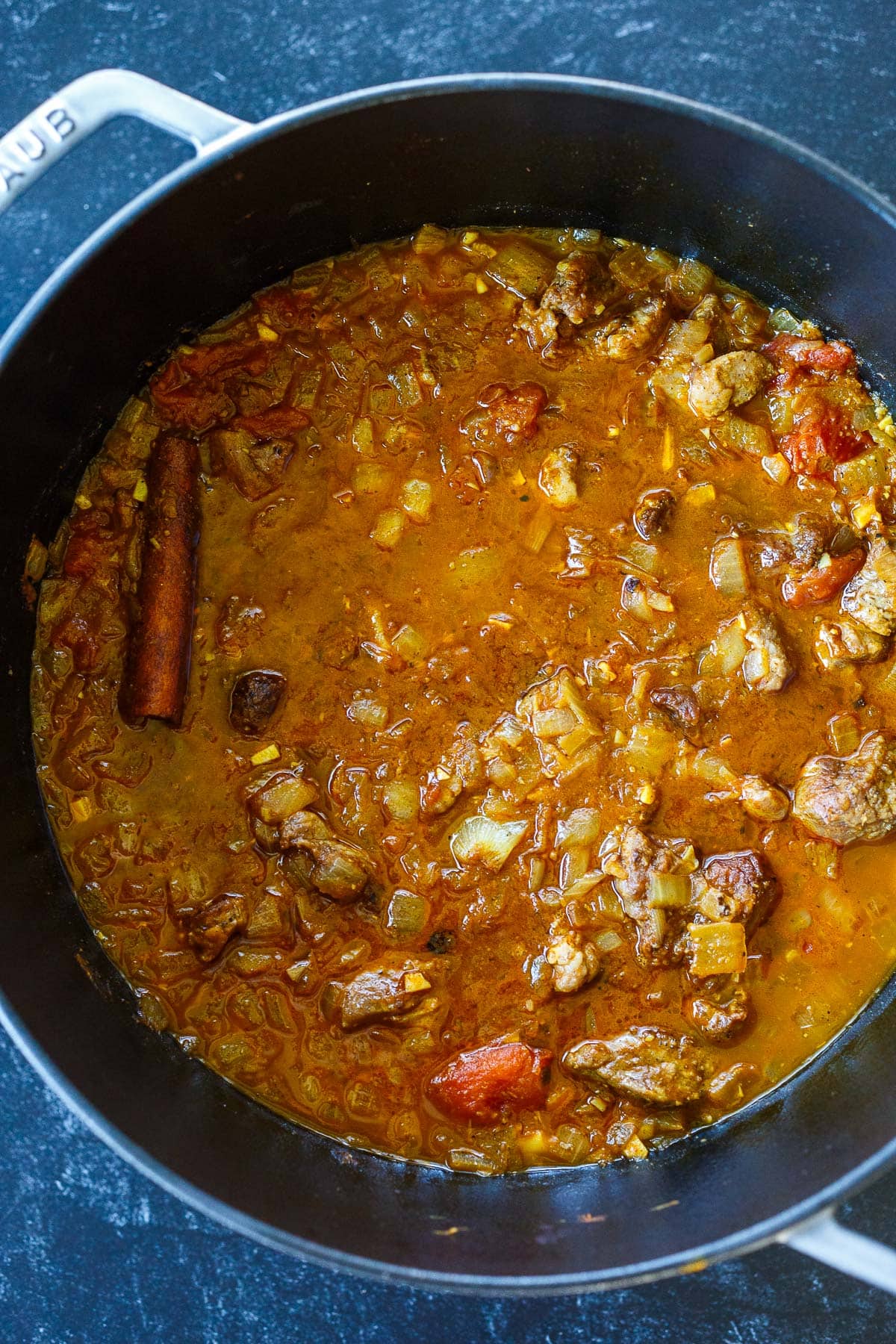 lamb tagine in pot with cinnamon stick.