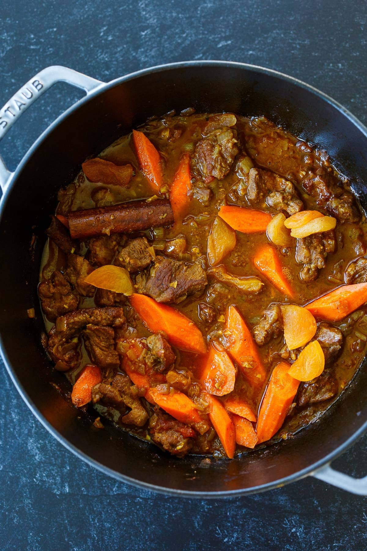 Dutch oven with brothy lamb tagine, one hour into cooking, with carrots and dried apricots added.