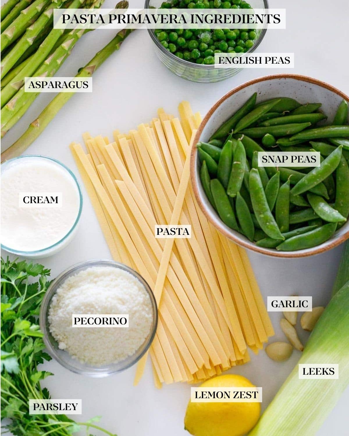 Ingredients for Pasta Primavera layed out on a white background.