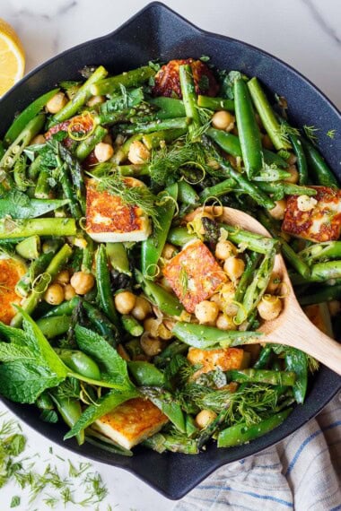 A bright, savory spring skillet dinner with golden halloumi, tender-crisp asparagus and snap peas, chickpeas, fresh herbs, and lemon. Easy, vegetarian, GF, and ready in 40 minutes.