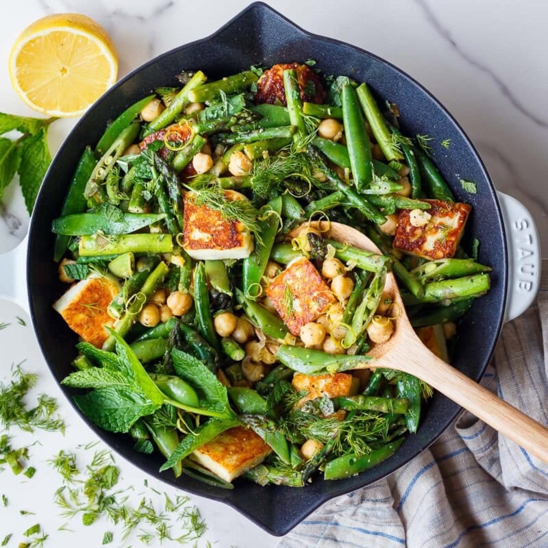 A bright, savory spring skillet dinner with golden halloumi, tender-crisp asparagus and snap peas, chickpeas, fresh herbs, and lemon. Easy, vegetarian, GF, and ready in 40 minutes.