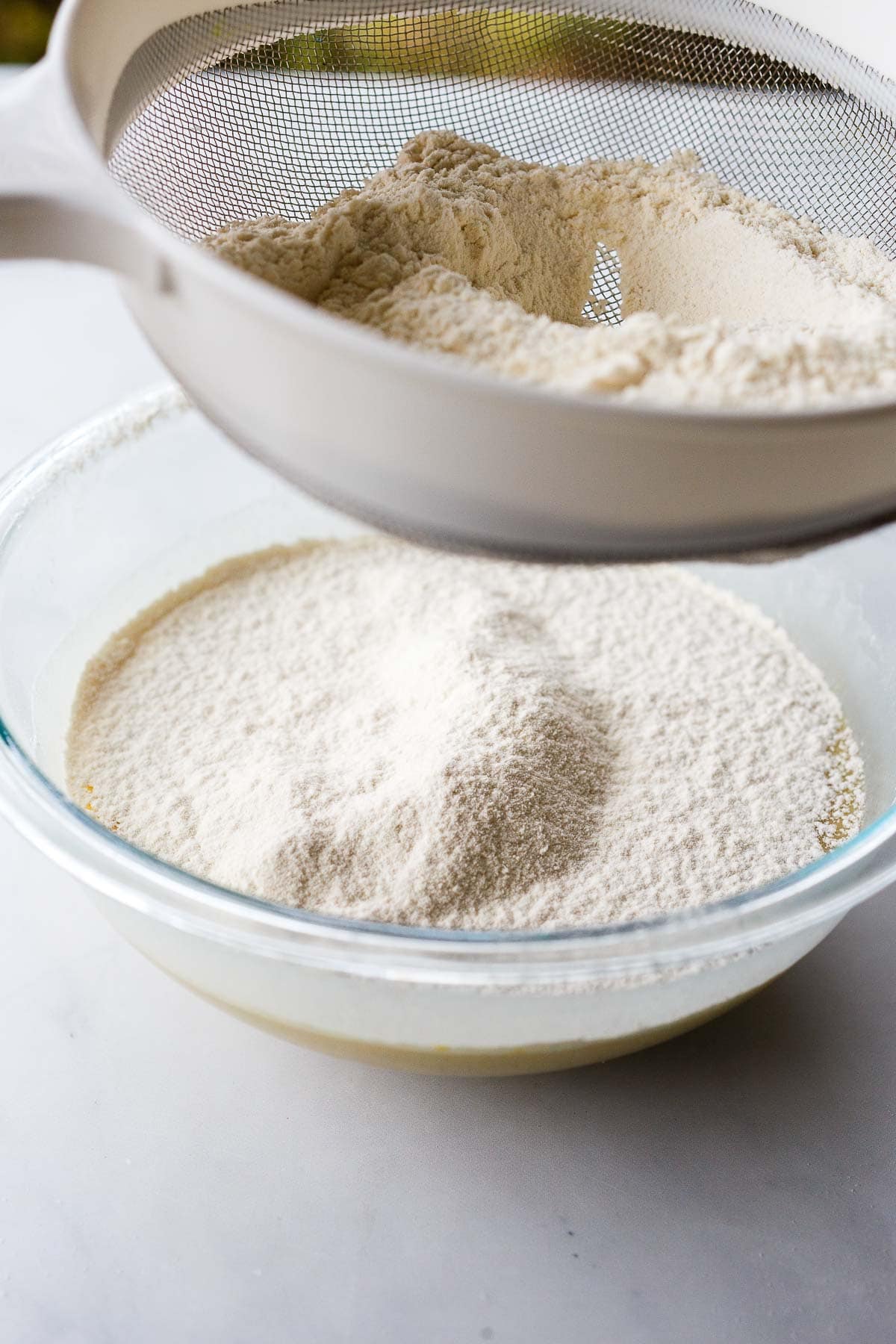 sifting flour into glass mixing bowl. 