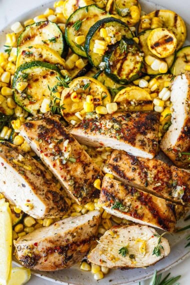 Mediterranean Grilled Chicken is an easy, flavor-packed summer dinner made with juicy herb-marinated chicken breasts, charred zucchini, and sweet grilled corn. Bright lemon, garlic, and fresh herbs infuse every bite! Gluten-free.