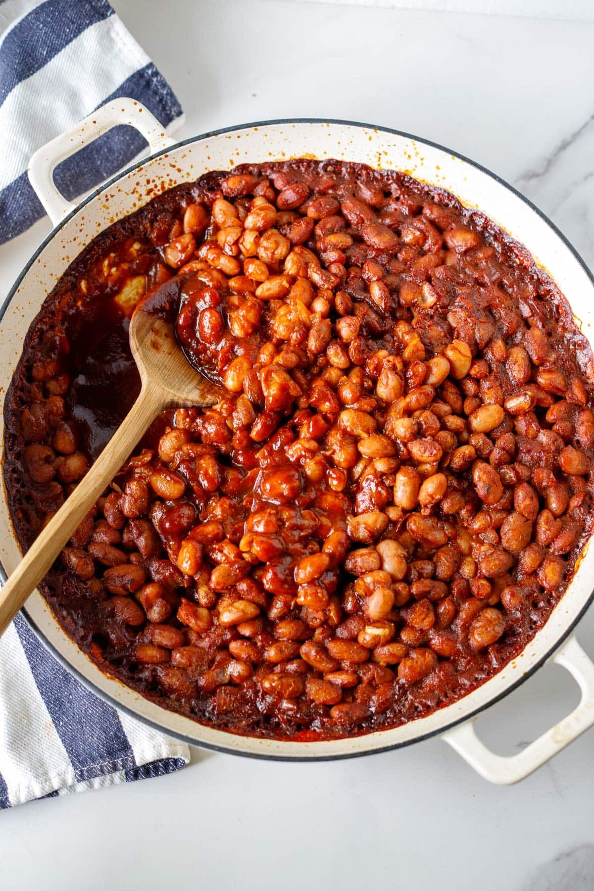 braiser with homemade baked beans bbq style with wood spoon.