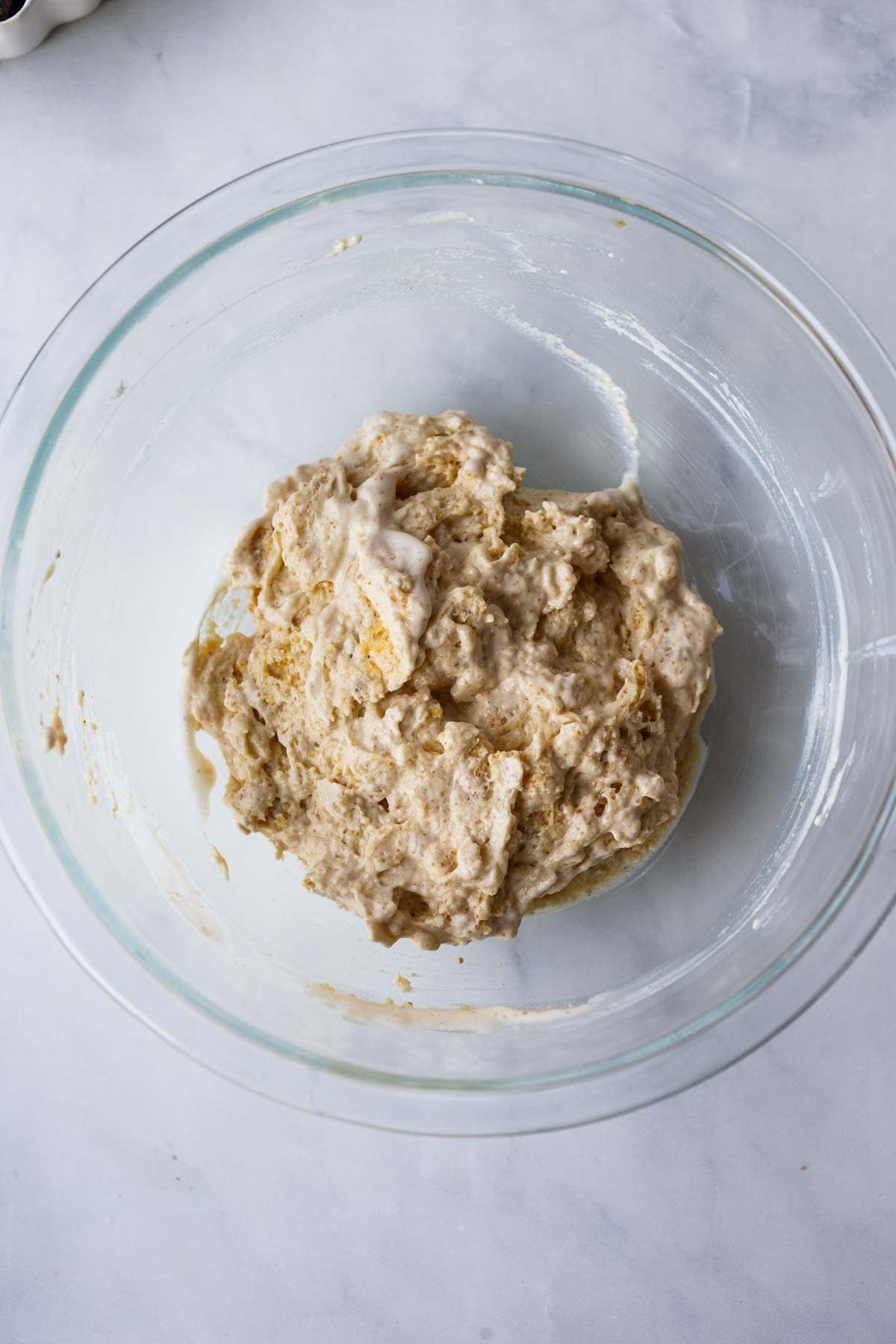 glass mixing bowl with biscuit topping mixture for cobbler.